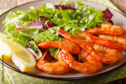 Honey soy king prawns and fresh salad close-up on a plate. horizontal