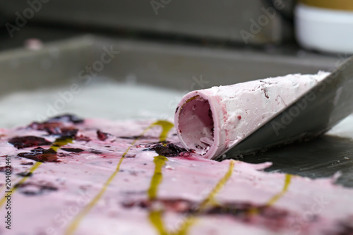 Thai roll ice cream is made by hand on the freezer. Sweet dessert made from natural berries and ingredients. The process of making food.