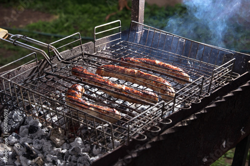 delicious grilled sausages, grilled meat, barbecue outdoors. photo