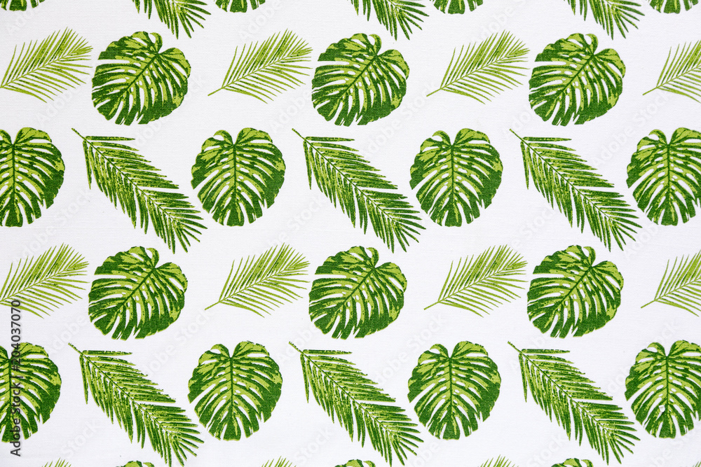 Palm leaves on white tablecloth fabric  picnic texture. Textile, napkin, tablecloth. View from above, top. Traditional pattern and color, pattern background. 