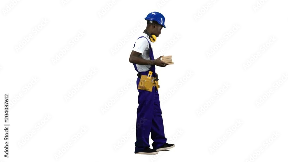 African American builder goes to work with wooden planks in his hands. Alpha channel. Side view African American builder goes to work with wooden planks in his hands. Alpha channel. Side view