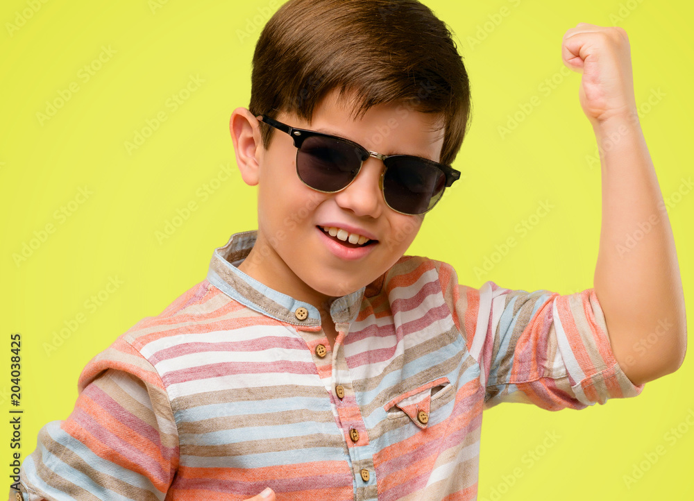 Handsome toddler child with green eyes happy and excited celebrating victory expressing big success, power, energy and positive emotions. Celebrates new job joyful over yellow background Handsome toddler child with green eyes happy and excited celebrating victory expressing big success, power, energy and positive emotions. Celebrates new job joyful over yellow background