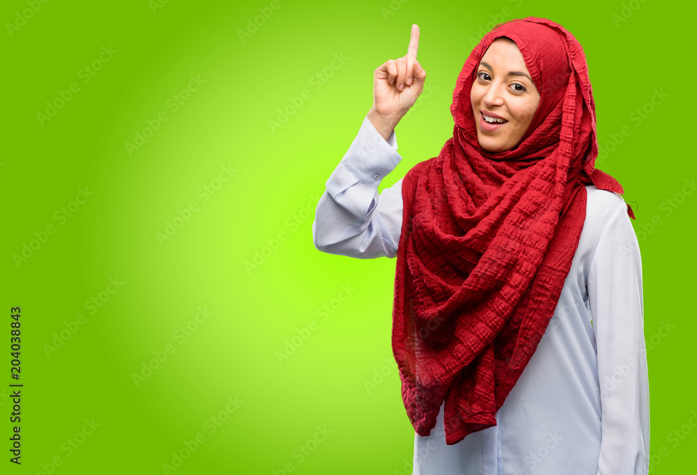 Young arab woman wearing hijab happy and surprised cheering expressing wow gesture pointing up Young arab woman wearing hijab happy and surprised cheering expressing wow gesture pointing up