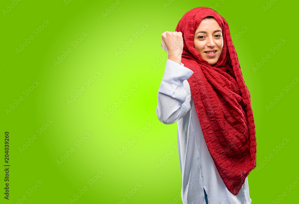 Young arab woman wearing hijab happy and excited expressing winning gesture. Successful and celebrating victory, triumphant Young arab woman wearing hijab happy and excited expressing winning gesture. Successful and celebrating victory, triumphant