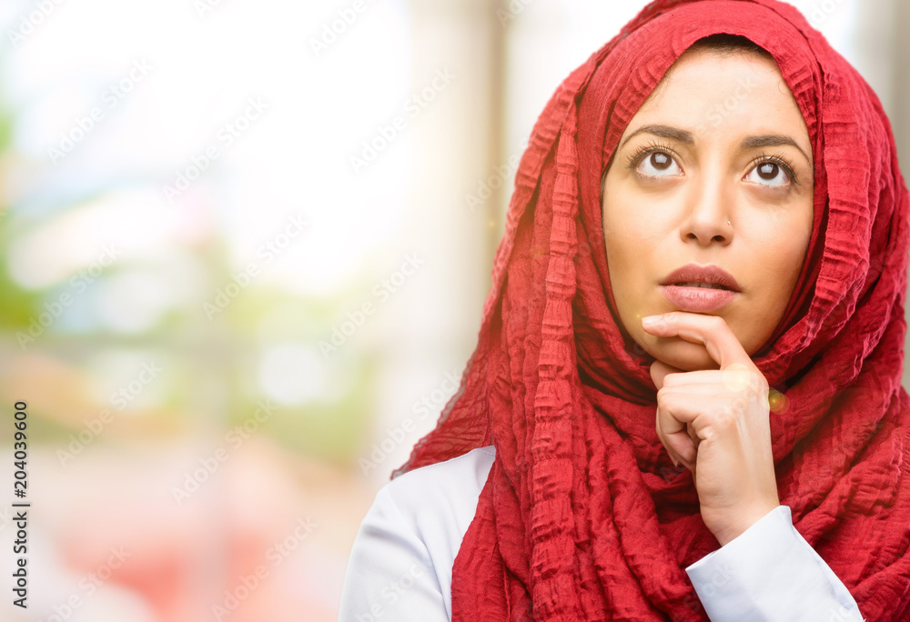 Young arab woman wearing hijab doubt expression, confuse and wonder concept, uncertain future Young arab woman wearing hijab doubt expression, confuse and wonder concept, uncertain future