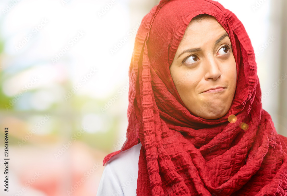 Young arab woman wearing hijab doubt expression, confuse and wonder concept, uncertain future Young arab woman wearing hijab doubt expression, confuse and wonder concept, uncertain future