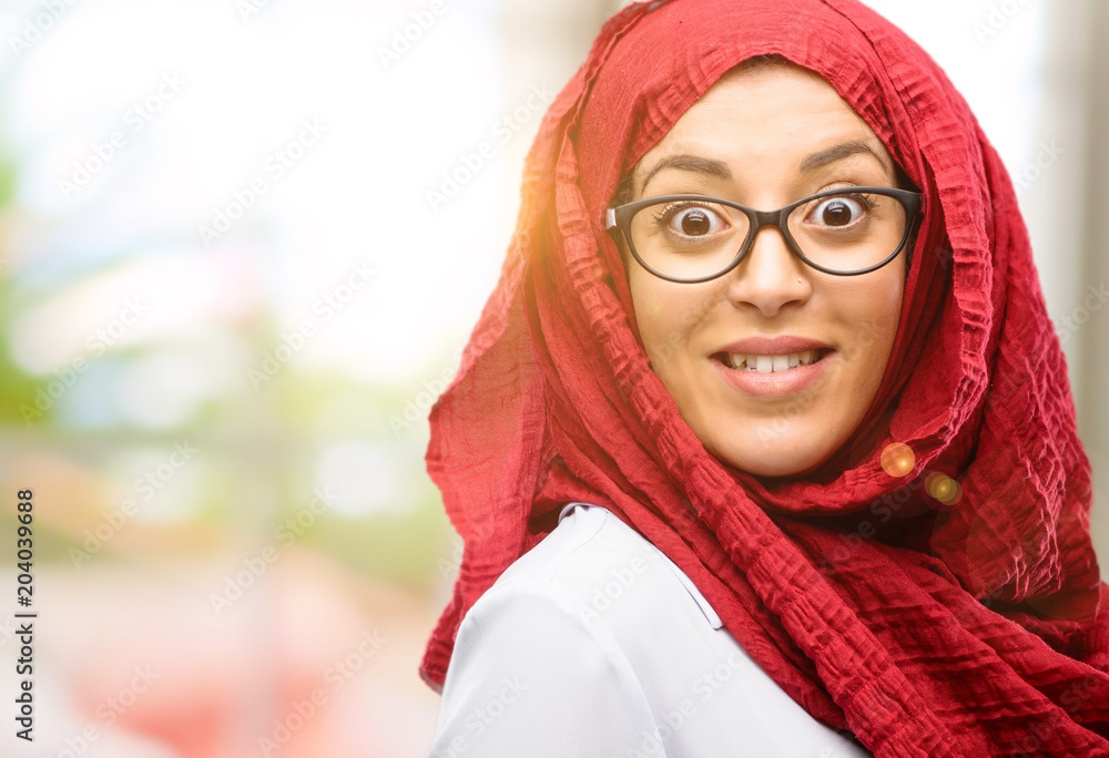 Young arab woman wearing hijab confident and happy with a big crazy smile laughing Young arab woman wearing hijab confident and happy with a big crazy smile laughing