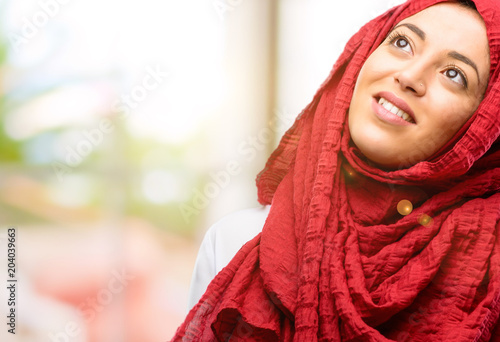 Young arab woman wearing hijab confident and happy with a big natural smile laughing looking up