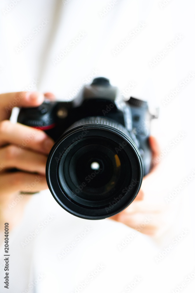 Girl hands holding photo camera, white background, copy space. Travel and shoot concept