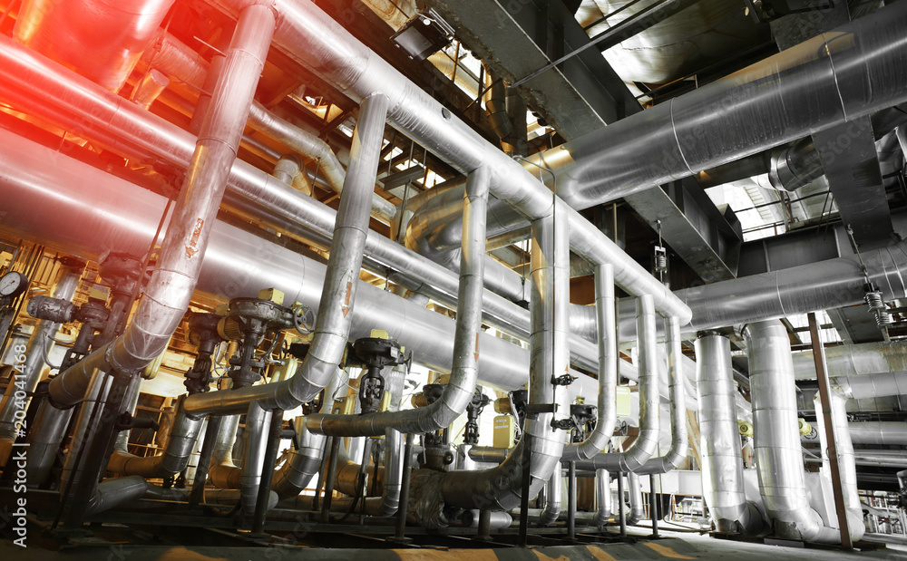 Equipment, cables and piping as found inside of a modern industrial power plant. Industrial zone, Steel pipelines, valves, cables and walkways Equipment, cables and piping as found inside of a modern industrial power plant. Industrial zone, Steel pipelines, valves, cables and walkways