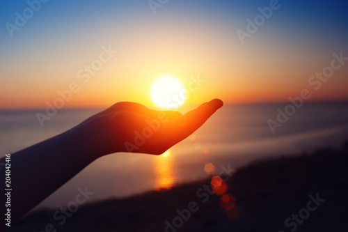 Sunset over the sea. The sun in a child's hand. © Anna