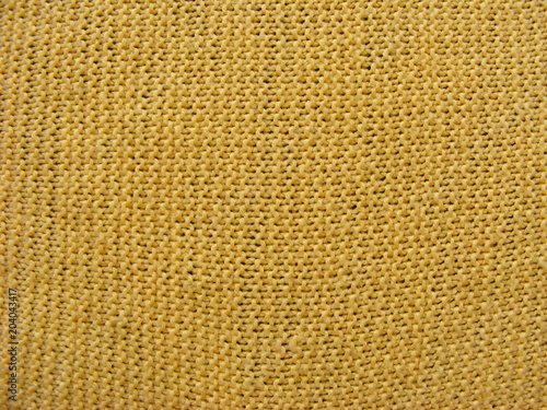Texture of knitted yellow ocher woolen fabric