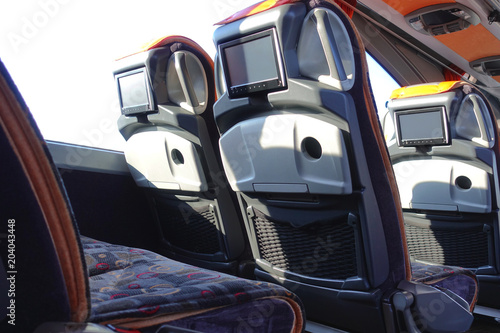 Intercity bus interior. Comfortable seats with monitors. © ravital