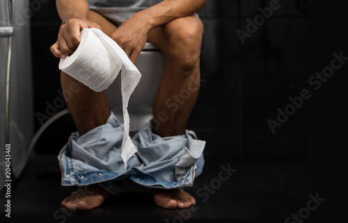 Canvas Print Man holding tissue roll in toilet of his house