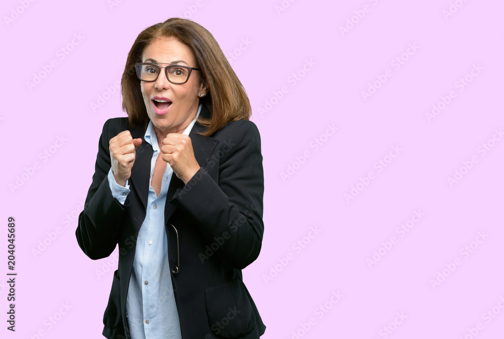Middle age business woman happy and surprised cheering expressing wow gesture Middle age business woman happy and surprised cheering expressing wow gesture