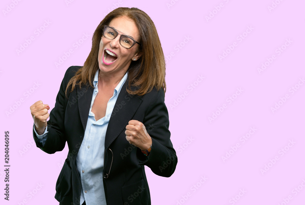 Middle age business woman happy and excited celebrating victory expressing big success, power, energy and positive emotions. Celebrates new job joyful Middle age business woman happy and excited celebrating victory expressing big success, power, energy and positive emotions. Celebrates new job joyful