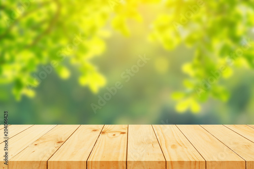 Wood floor with blurred trees of nature park background and summer season  product display montage