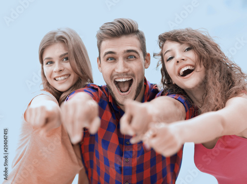 closeup of three happy young people showing hands forward