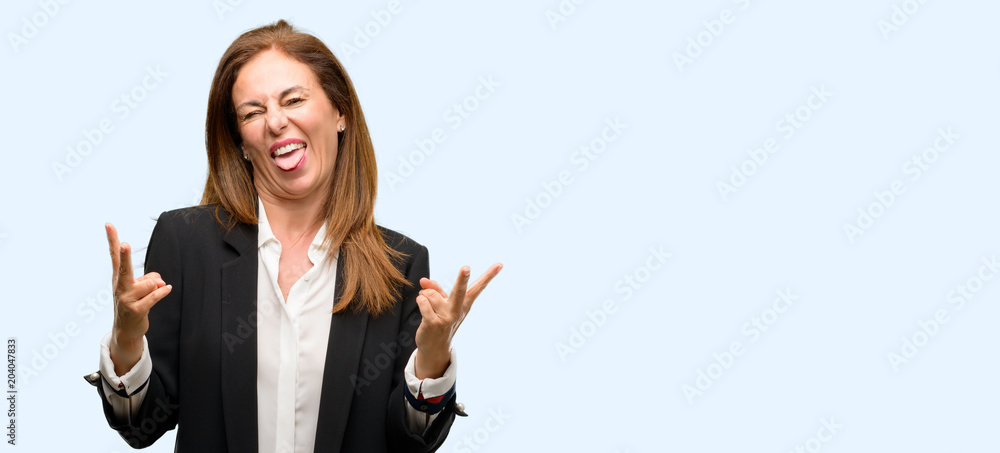 Middle age woman wearing jacket looking at camera showing tong and making victory sign with fingers isolated blue background Middle age woman wearing jacket looking at camera showing tong and making victory sign with fingers isolated blue background
