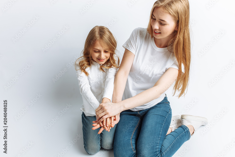 Mom and little daughter looking at each other, happy family, isolated background, cute and beautiful Mom and little daughter looking at each other, happy family, isolated background, cute and beautiful