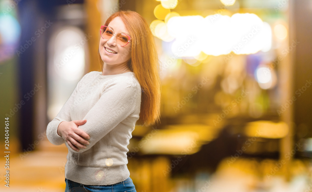 Fototapeta premium Beautiful young redhead woman confident and happy with a big natural smile laughing, natural expression at night
