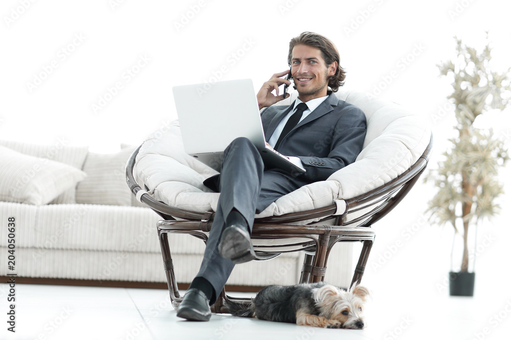 business man talking on a smartphone sitting in the living room business man talking on a smartphone sitting in the living room