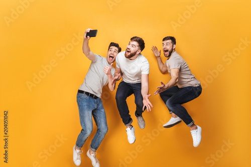 Three young smiling men taking a selfie
