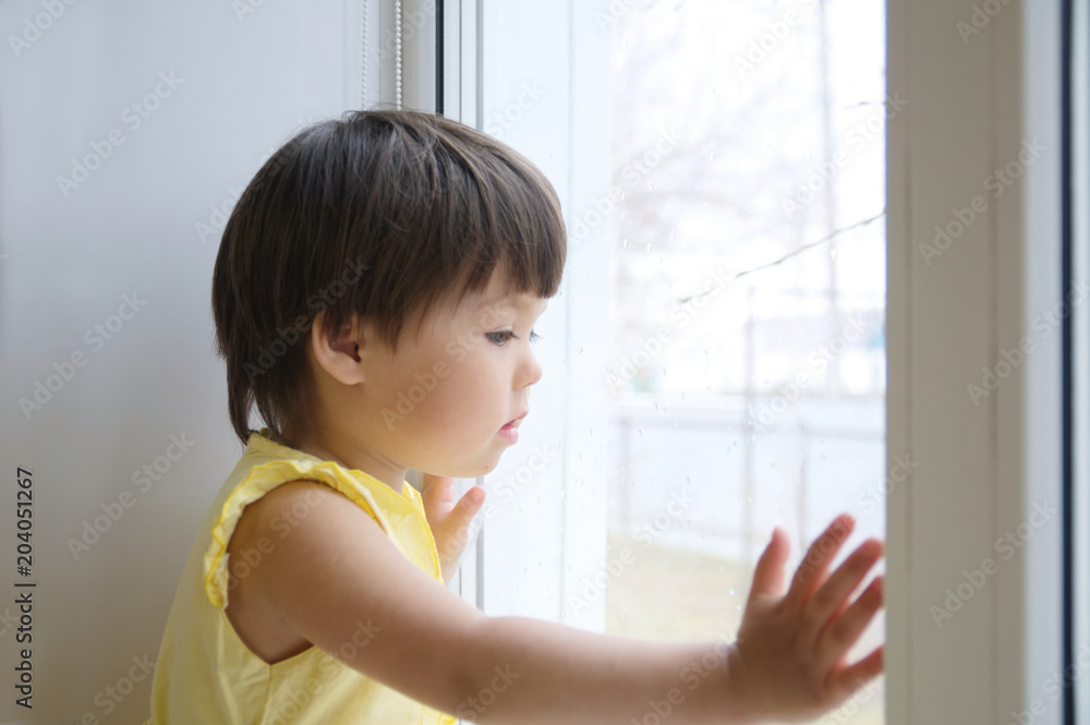 little girl looking out the window longing for some sunshine. curiosity childness. child sitting home at rainy day little girl looking out the window longing for some sunshine. curiosity childness. child sitting home at rainy day