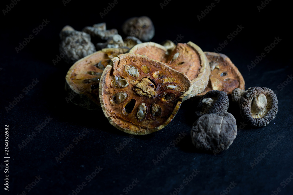 Dry bael fruit tea and Mushroom isolated on black background
Dry bael fruit tea and Mushroom isolated on black background