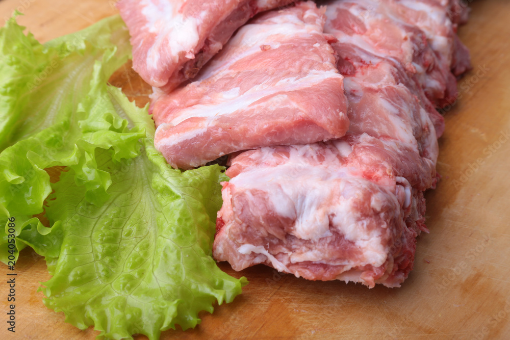 Raw Ribs on a rustic cutting board with salt, pepper and grinder for spices . copy space. Top View. Raw Ribs on a rustic cutting board with salt, pepper and grinder for spices . copy space. Top View.