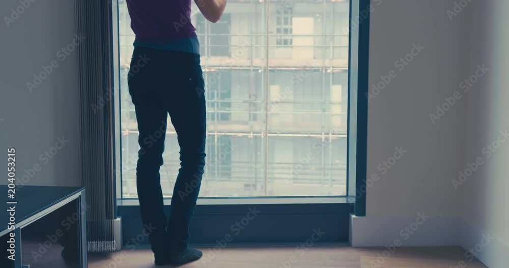 Tilting shot of woman with coffee by window in city Tilting shot of woman with coffee by window in city