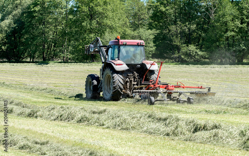 Fényképezés tracteur agricole qui rassemble le foin sur le champ en activité