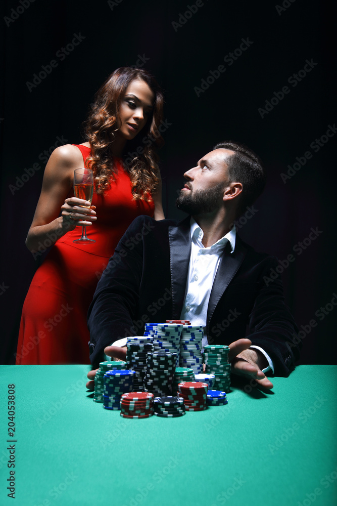 woman and man at the poker table with chips and drinks woman and man at the poker table with chips and drinks