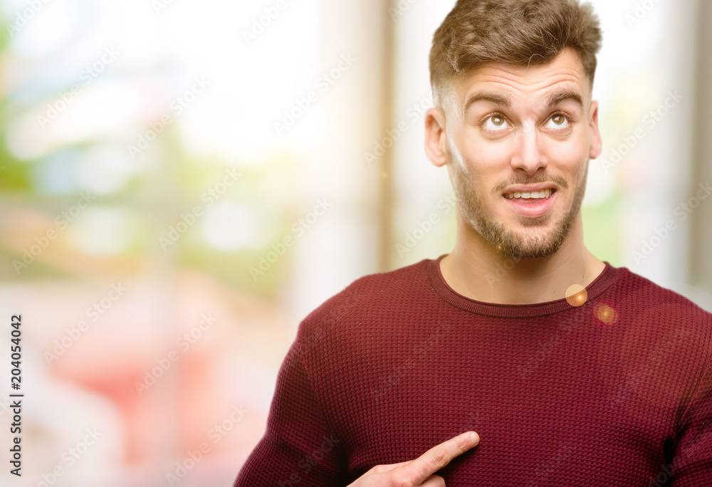Handsome young man happy and surprised cheering expressing wow gesture pointing up Handsome young man happy and surprised cheering expressing wow gesture pointing up