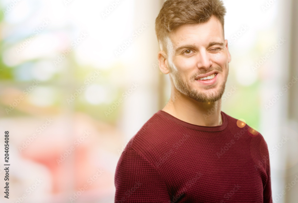 Handsome young man blinking eyes with happy gesture Handsome young man blinking eyes with happy gesture