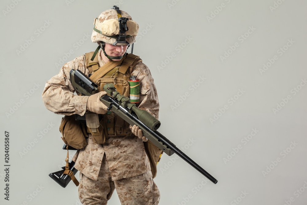 Soldier in camouflage holding rifle Soldier in camouflage holding rifle