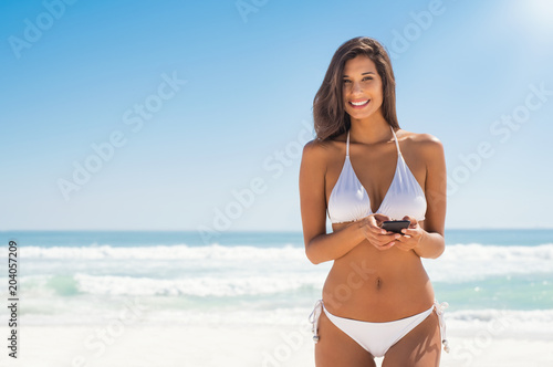 Woman in bikini using phone