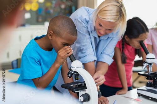 Children scholar looking through microscope
