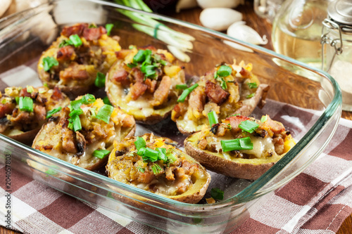 Baked potatoes in jacket stuffed with bacon, mushrooms and cheese. Dish served in baking dish..Baked potatoes stuffed with bacon, mushrooms and cheese