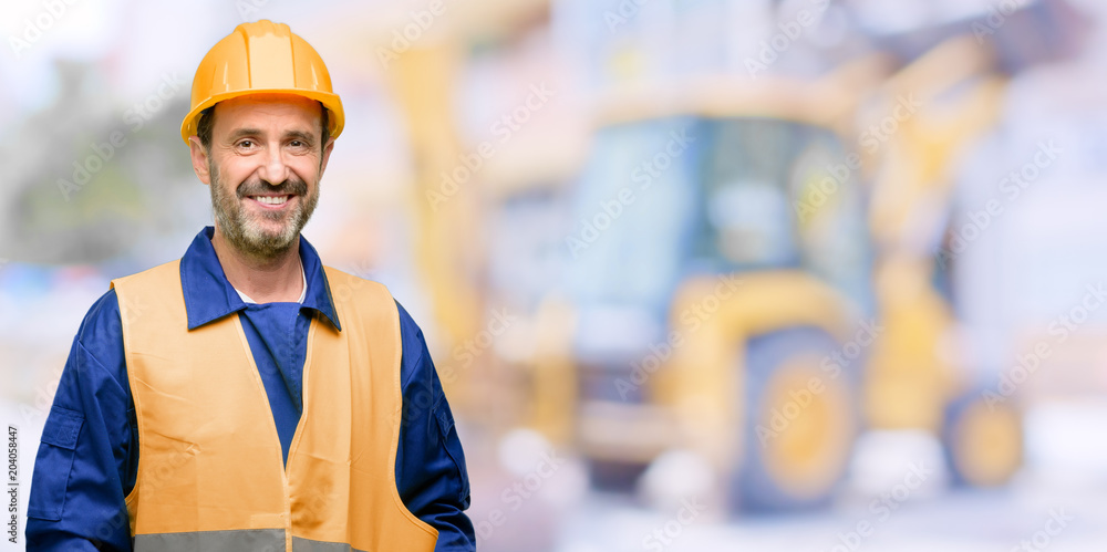 Senior engineer man, construction worker confident and happy with a big natural smile laughing at work Senior engineer man, construction worker confident and happy with a big natural smile laughing at work