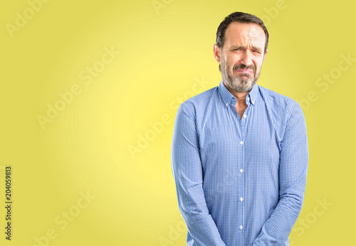 Handsome middle age man with sad and upset expression, unhappy