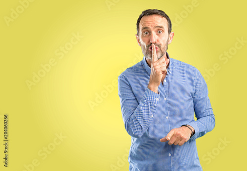 Handsome middle age man with index finger on lips, ask to be quiet. Silence and secret concept © Krakenimages.com