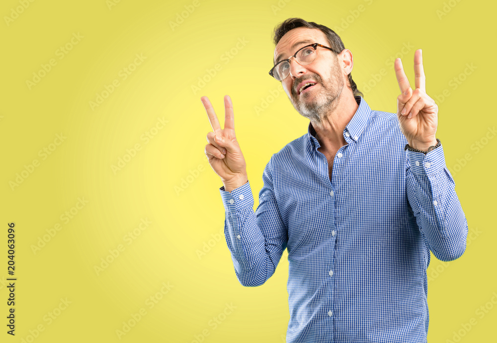 Handsome middle age man happy and excited expressing winning gesture. Successful and celebrating victory, triumphant Handsome middle age man happy and excited expressing winning gesture. Successful and celebrating victory, triumphant