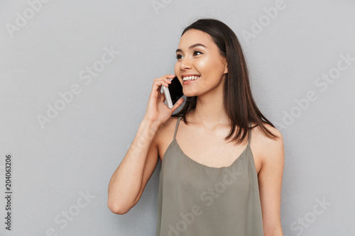 Portrait of a smiling asian woman talking on mobile phone