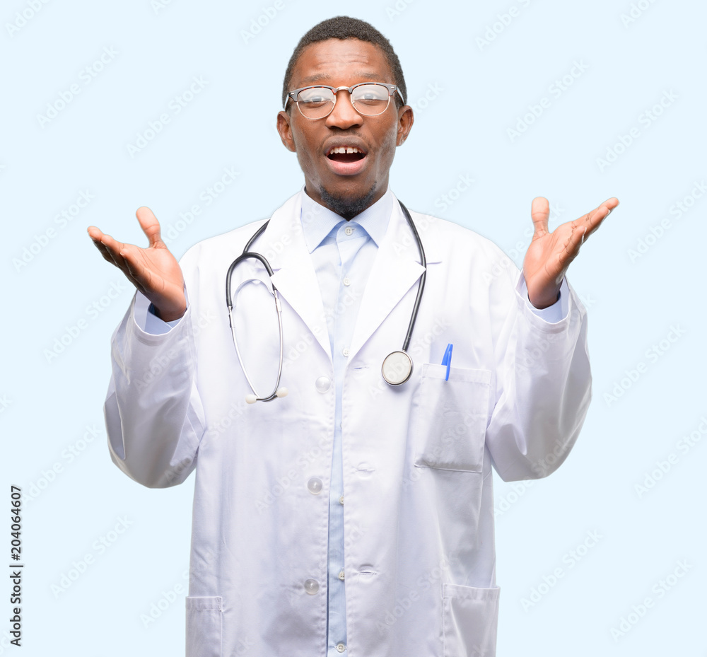 Young black doctor, medical professional happy and surprised cheering expressing wow gesture Young black doctor, medical professional happy and surprised cheering expressing wow gesture