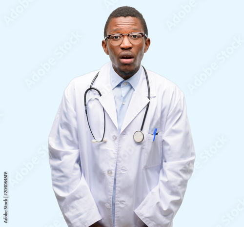 Young black doctor, medical professional scared in shock, expressing panic and fear
