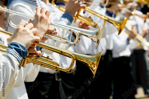 Closeup of children's brass band. Children play on golden pipes. photo