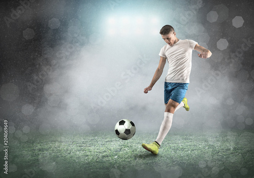Soccer player on a football field in dynamic action at summer day © Andrii IURLOV