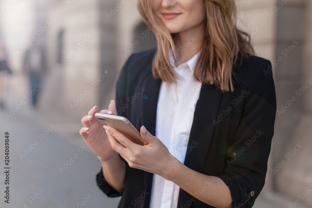 Cropped shot of young girl using modern smartphone device, female hands holding mobile phone on city street, smiling successful female entrepreneur using cellphone wireless connection for work outside Cropped shot of young girl using modern smartphone device, female hands holding mobile phone on city street, smiling successful female entrepreneur using cellphone wireless connection for work outside