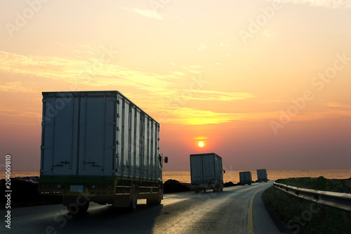 Truck on highway road with container, transportation concept.,import,export logistic industrial Transporting Land transport on asphalt expressway with sunrise sky